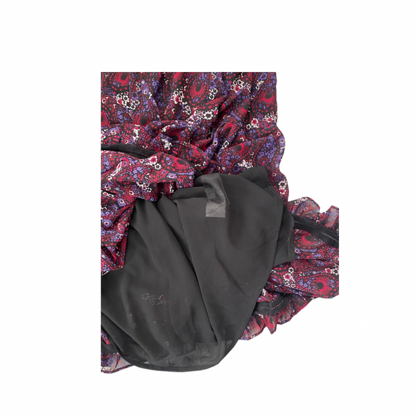 Paisley-patterned fabric  dress hem and black lining underneath on a white background