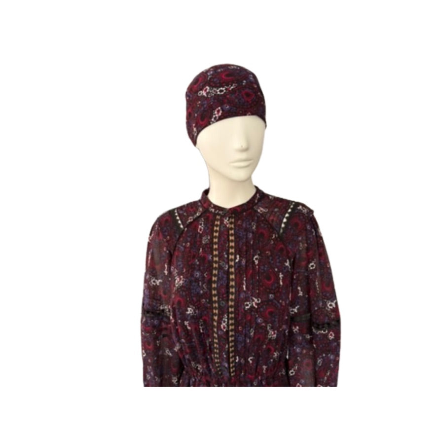 Mannequin wearing a patterned outfit with a matching headscarf on a white background