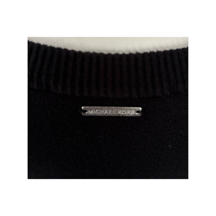 Black knit sweater with a visible brand label on a white background