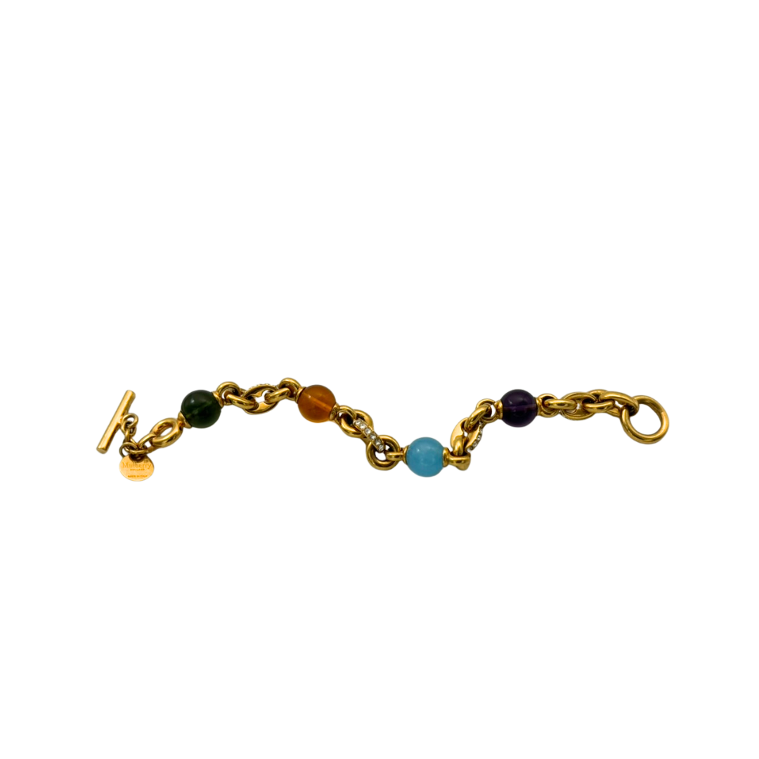 Gold bracelet with colored beads on a white background