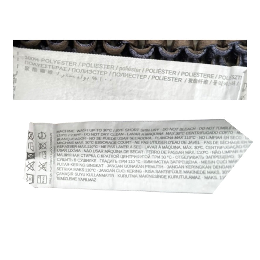 Close-up of fabric label with text and symbols on a white background