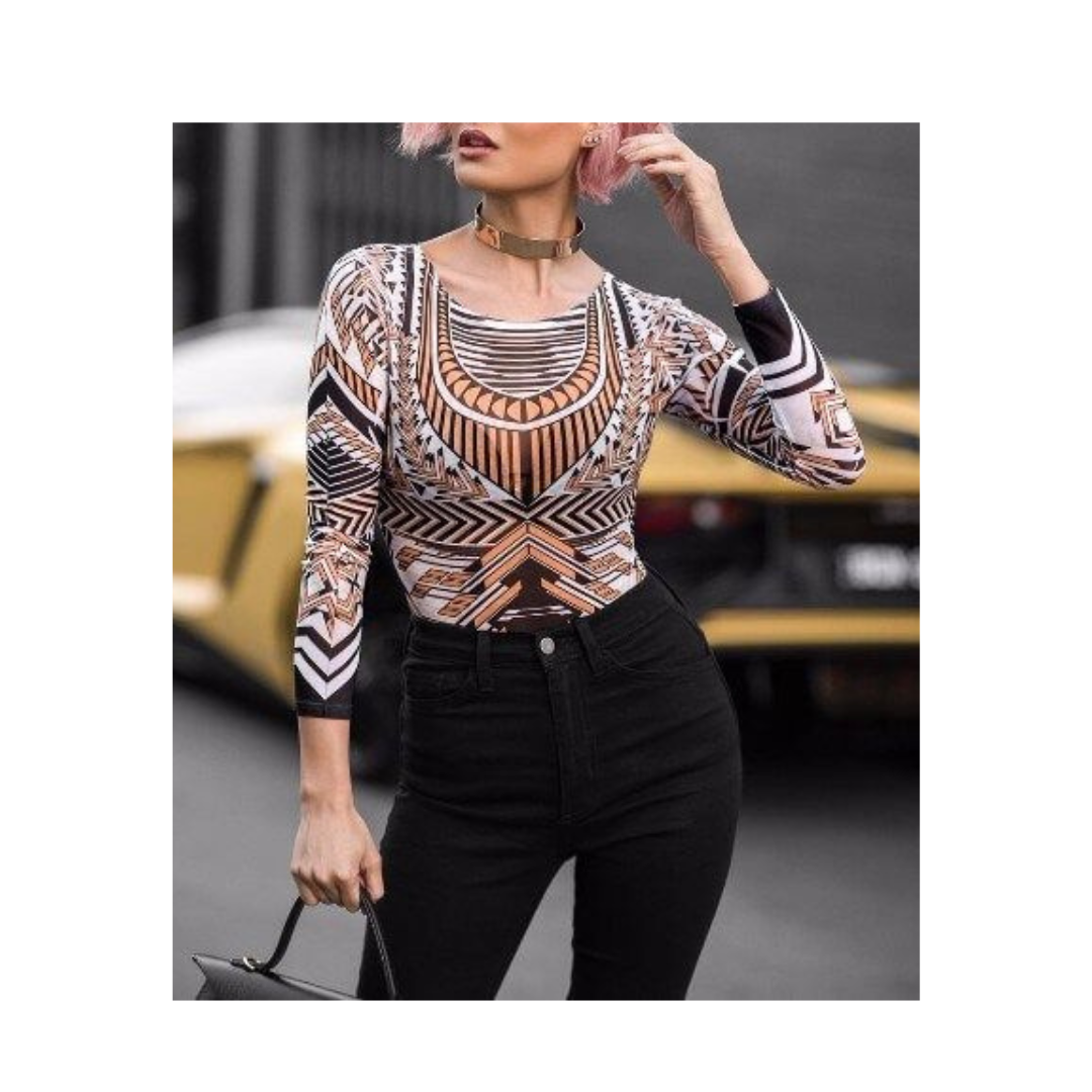 Woman wearing a patterned top and black pants with a blurred background