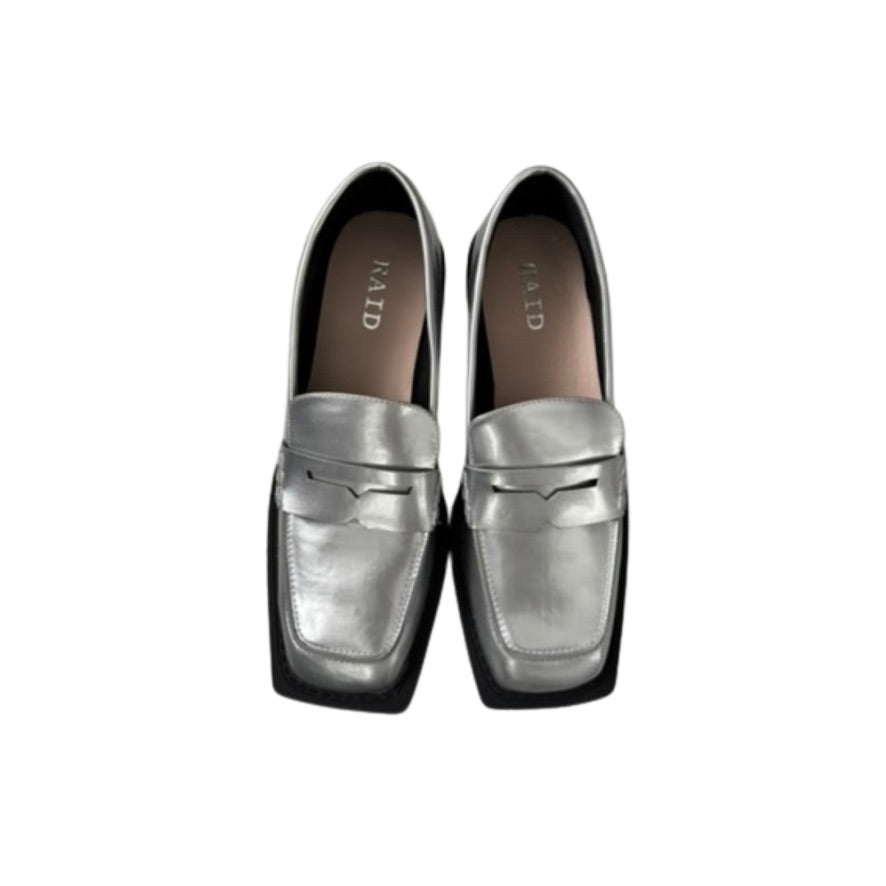 Pair of silver loafers with black soles on a white background