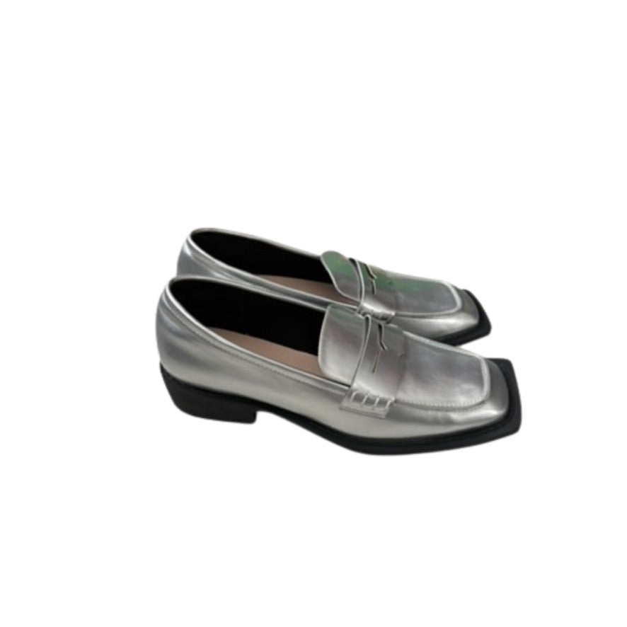 Silver loafers with a strap on a white background