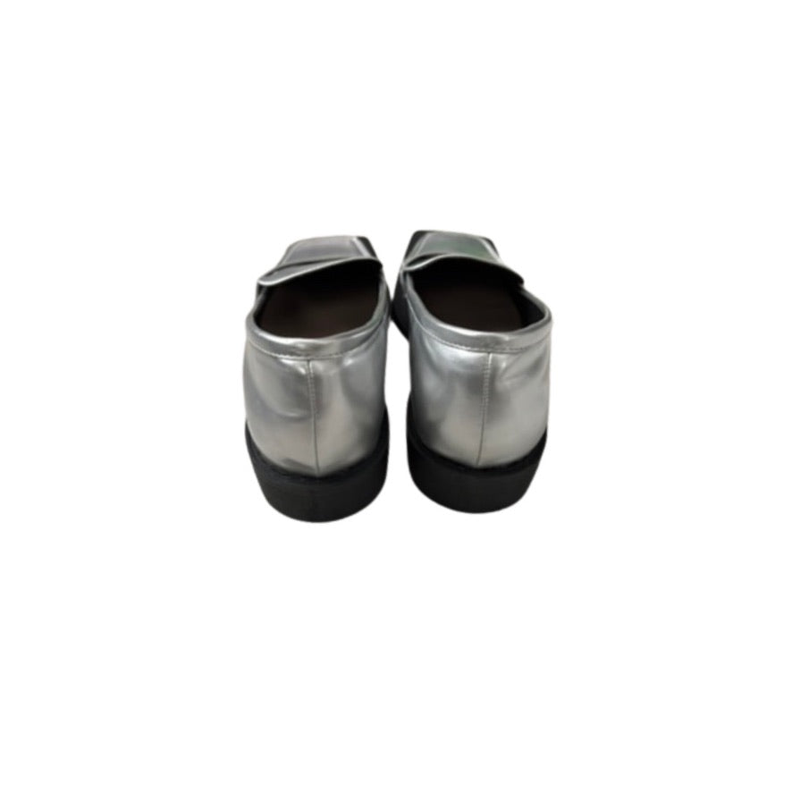 Pair of silver metallic shoes with black soles on a white background