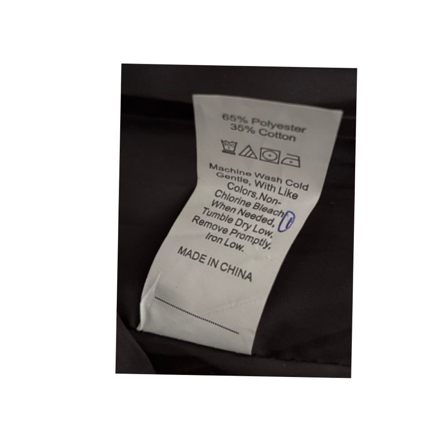 Clothing label with washing instructions on a black fabric background