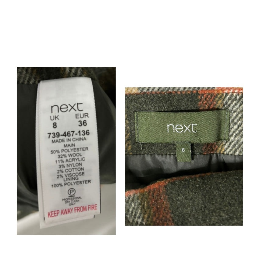 Clothing labels with 'next' branding on a plaid fabric background