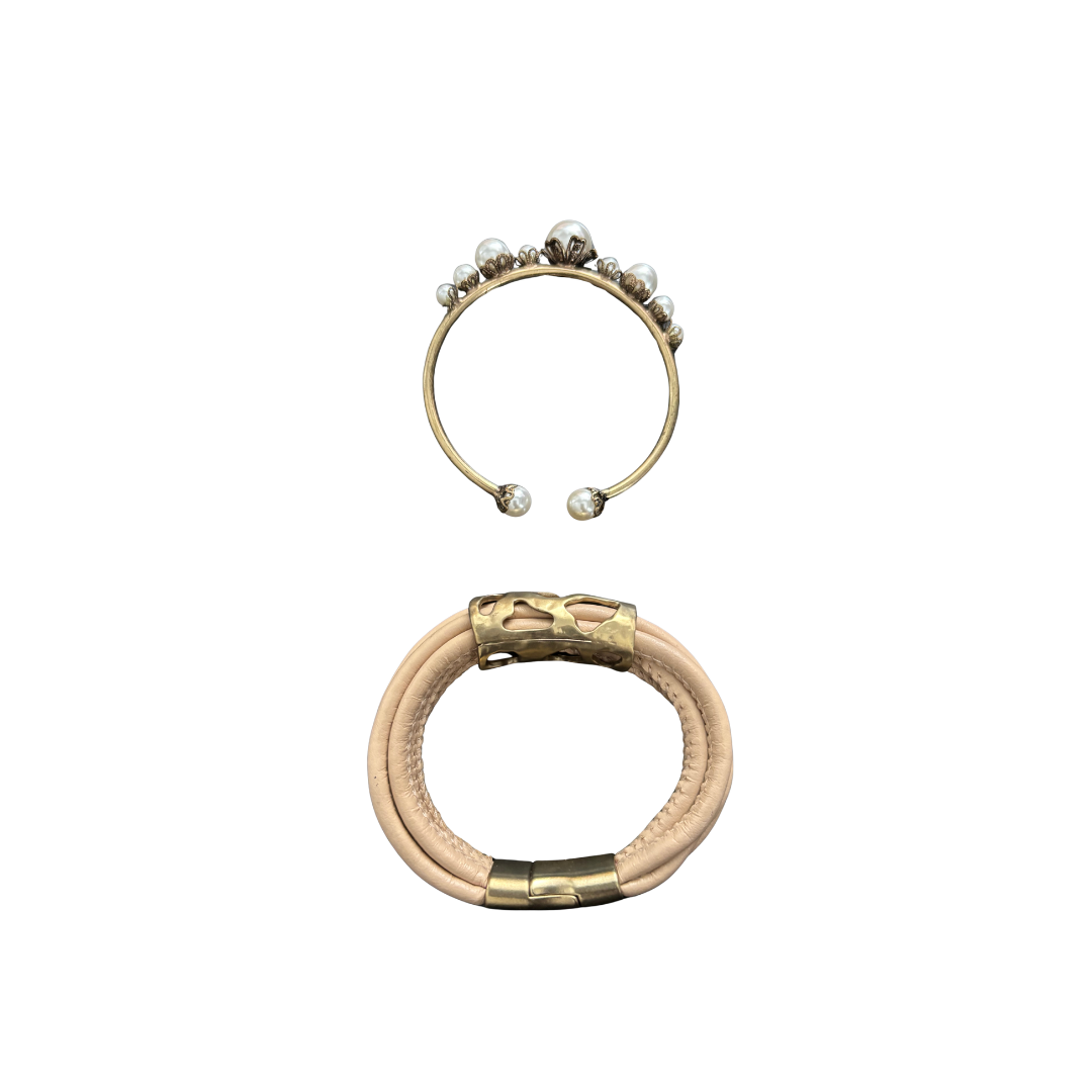 Two gold bracelets with pearl accents on a white background