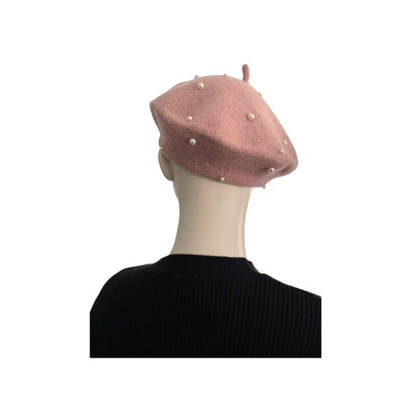 Pink beret with pearl embellishments on a mannequin head against a white background