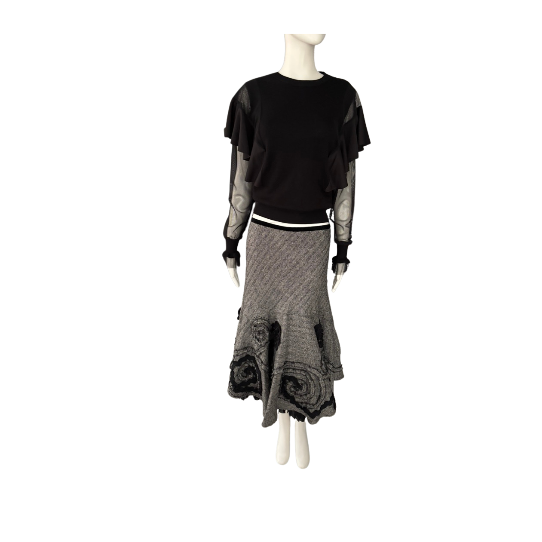 Mannequin wearing a black top and gray skirt on a white background