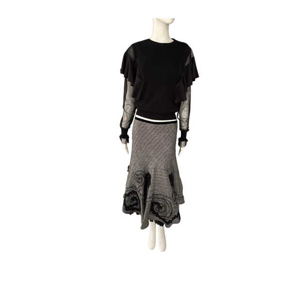 Mannequin wearing a black top and gray skirt on a white background
