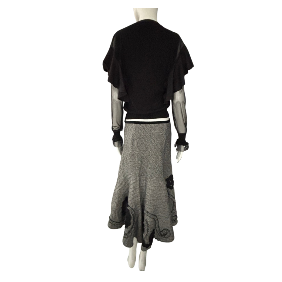 Mannequin wearing a black top and grey skirt on a white background