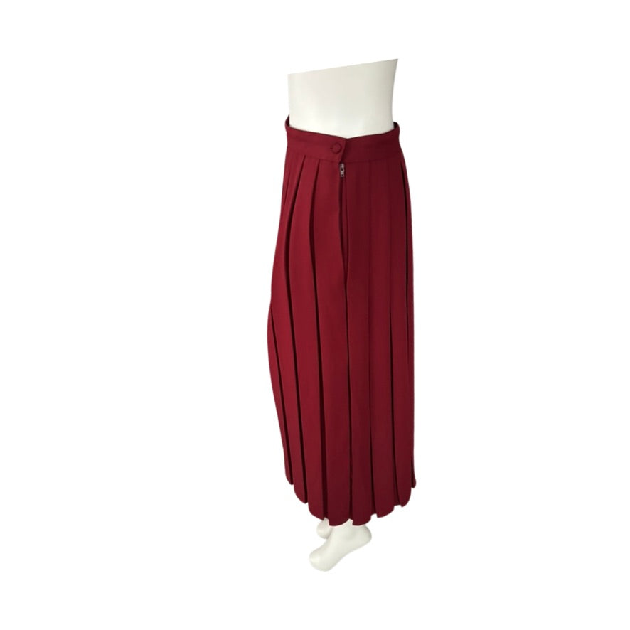 Red pleated skirt on a mannequin against a white background