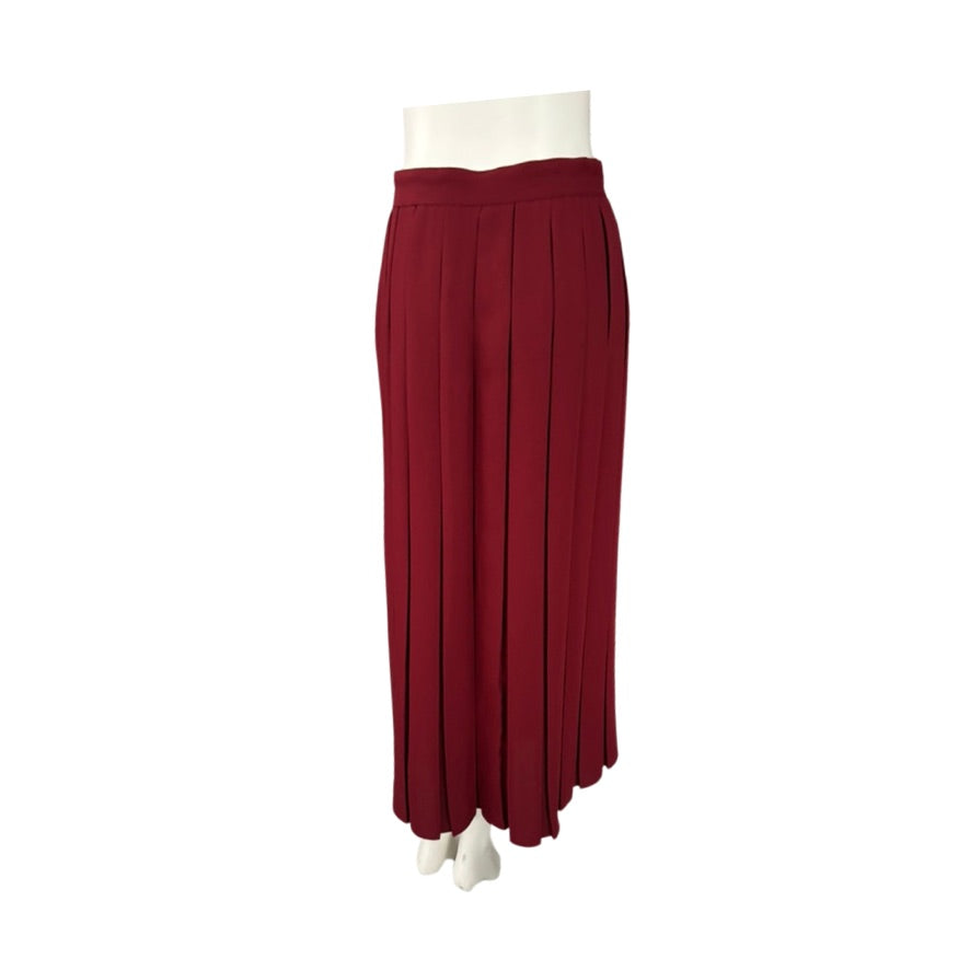 Red pleated skirt on a mannequin against a white background