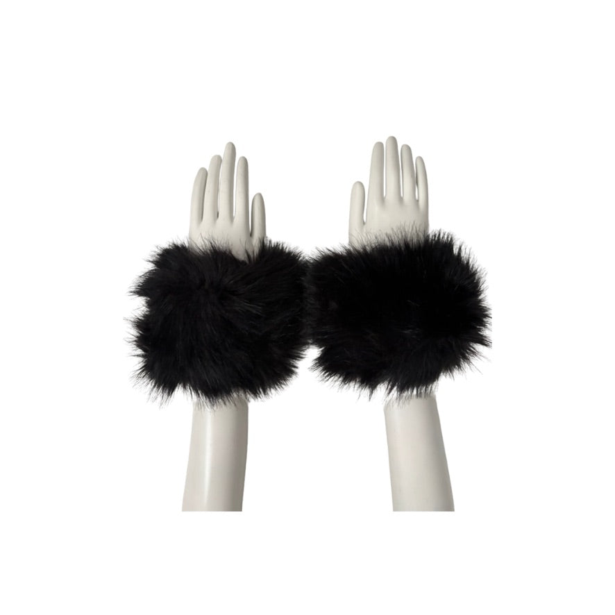 Black fur wrist cuffs on white mannequin hands against a white background