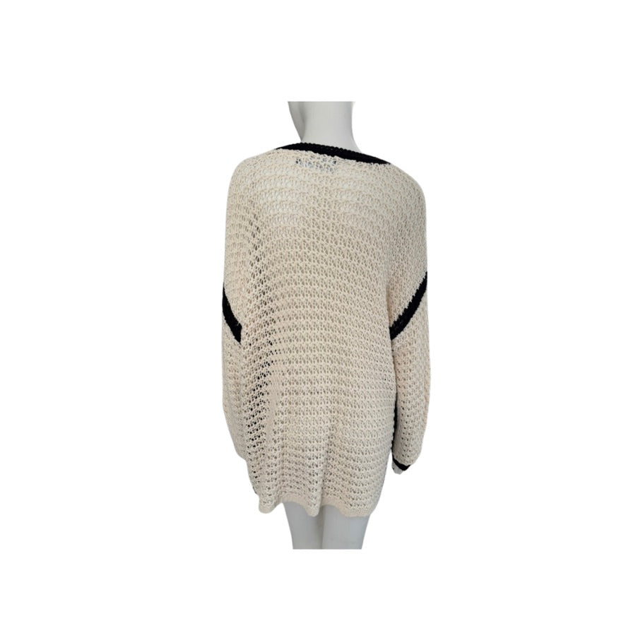 Beige knitted sweater with black accents on a mannequin against a white background