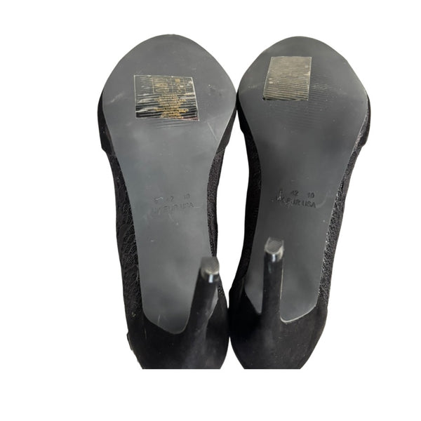 Black high-heeled shoes with visible brand labels on a white background