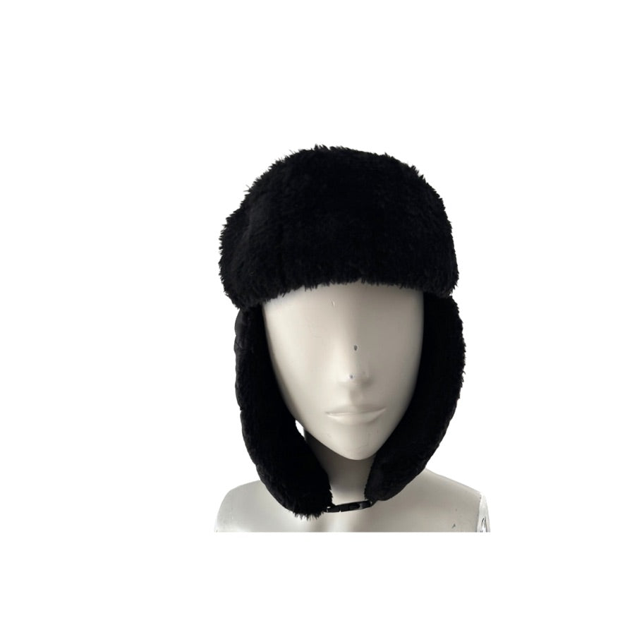 Black fur hat on a mannequin head against a white background