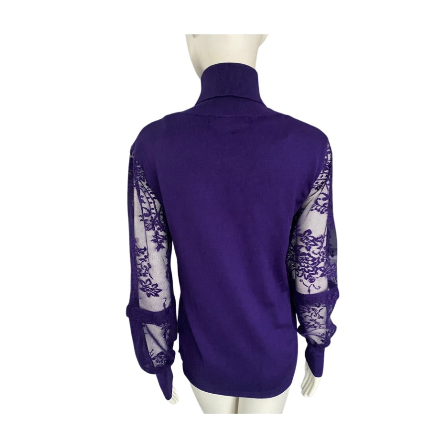 Purple turtleneck sweater with sheer sleeves on a mannequin against a white background