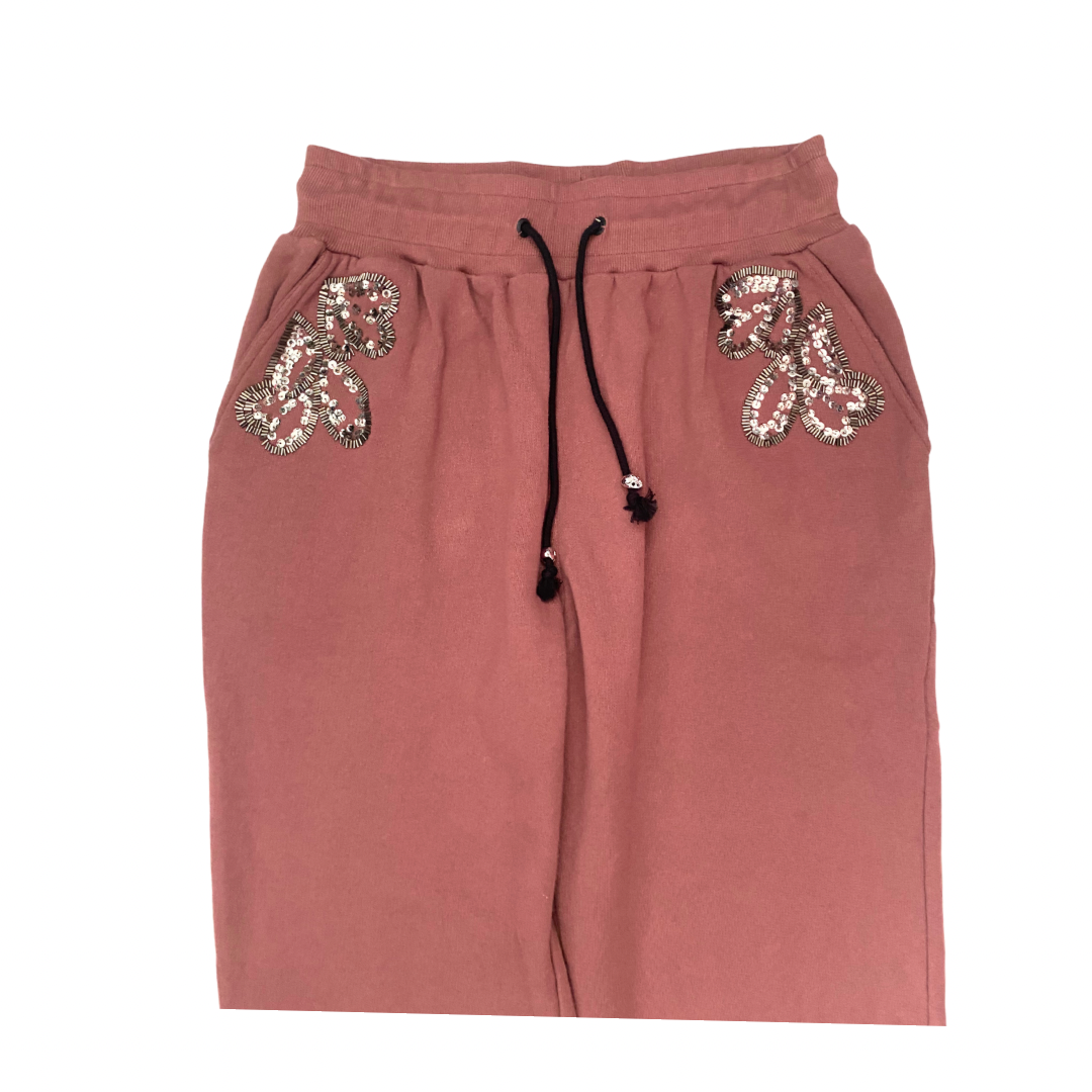 Pink sweatpants with sequin embellishments on a white background