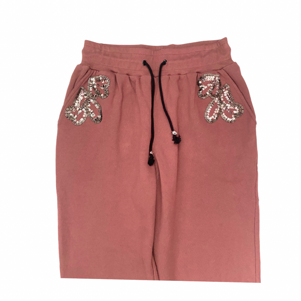Pink sweatpants with sequin embellishments on a white background