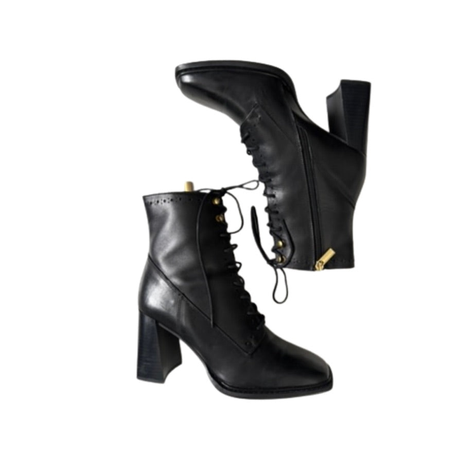Black leather boots with block heels on a white background