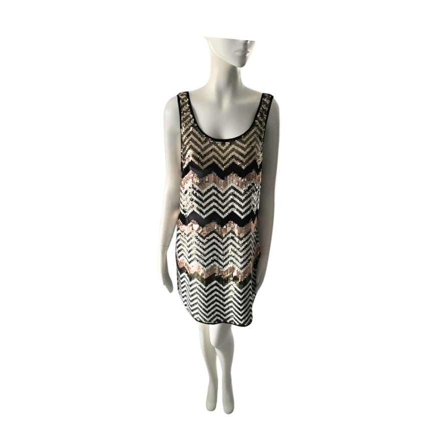 Mannequin wearing a sleeveless dress with a black and gold zigzag pattern on a white background