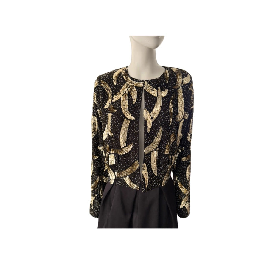 Mannequin wearing a black and gold patterned top on a white background