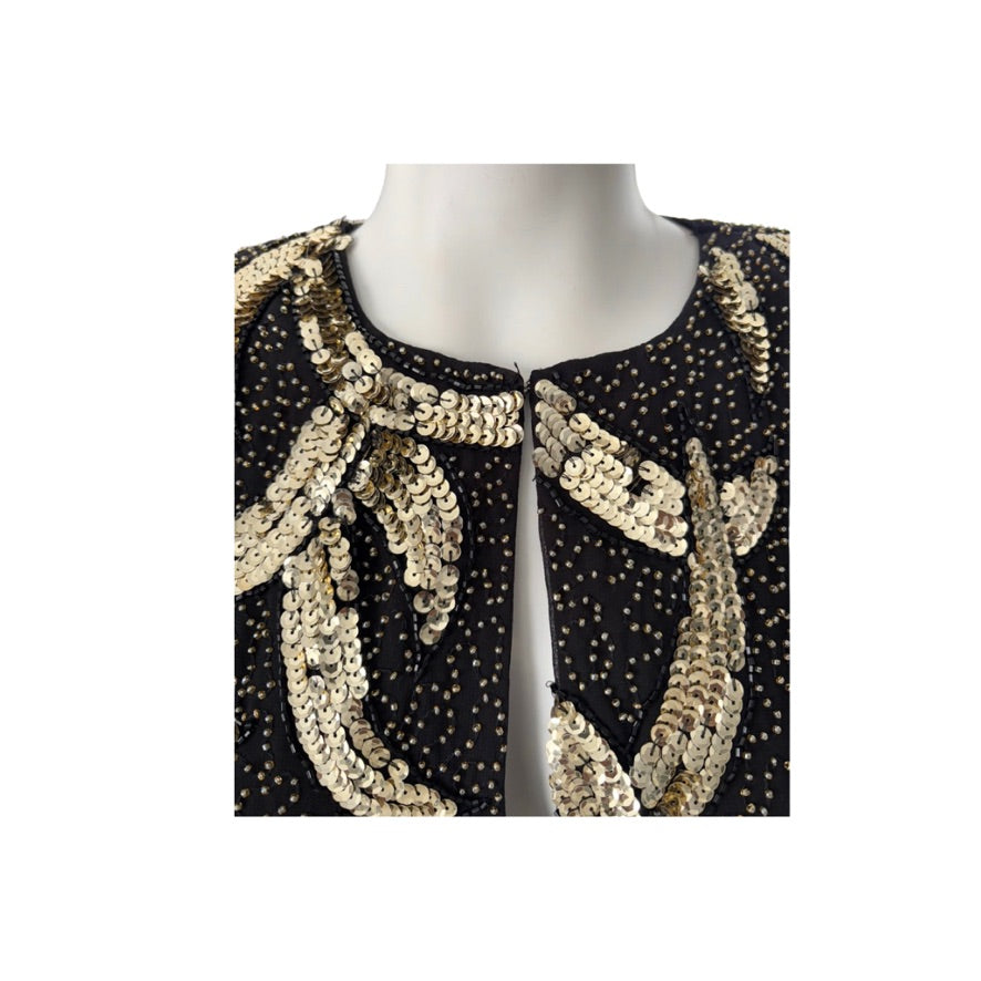 Black dress with gold sequin embellishments on a mannequin against a white background