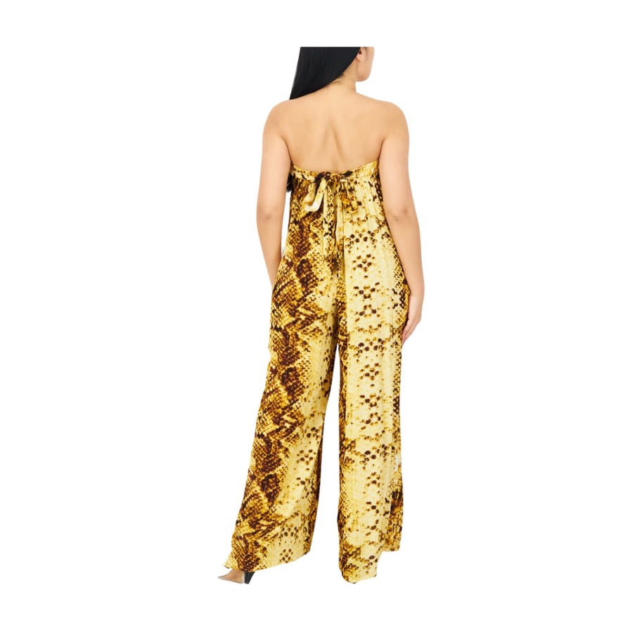 Woman wearing a yellow snake print strapless jumpsuit on a white background