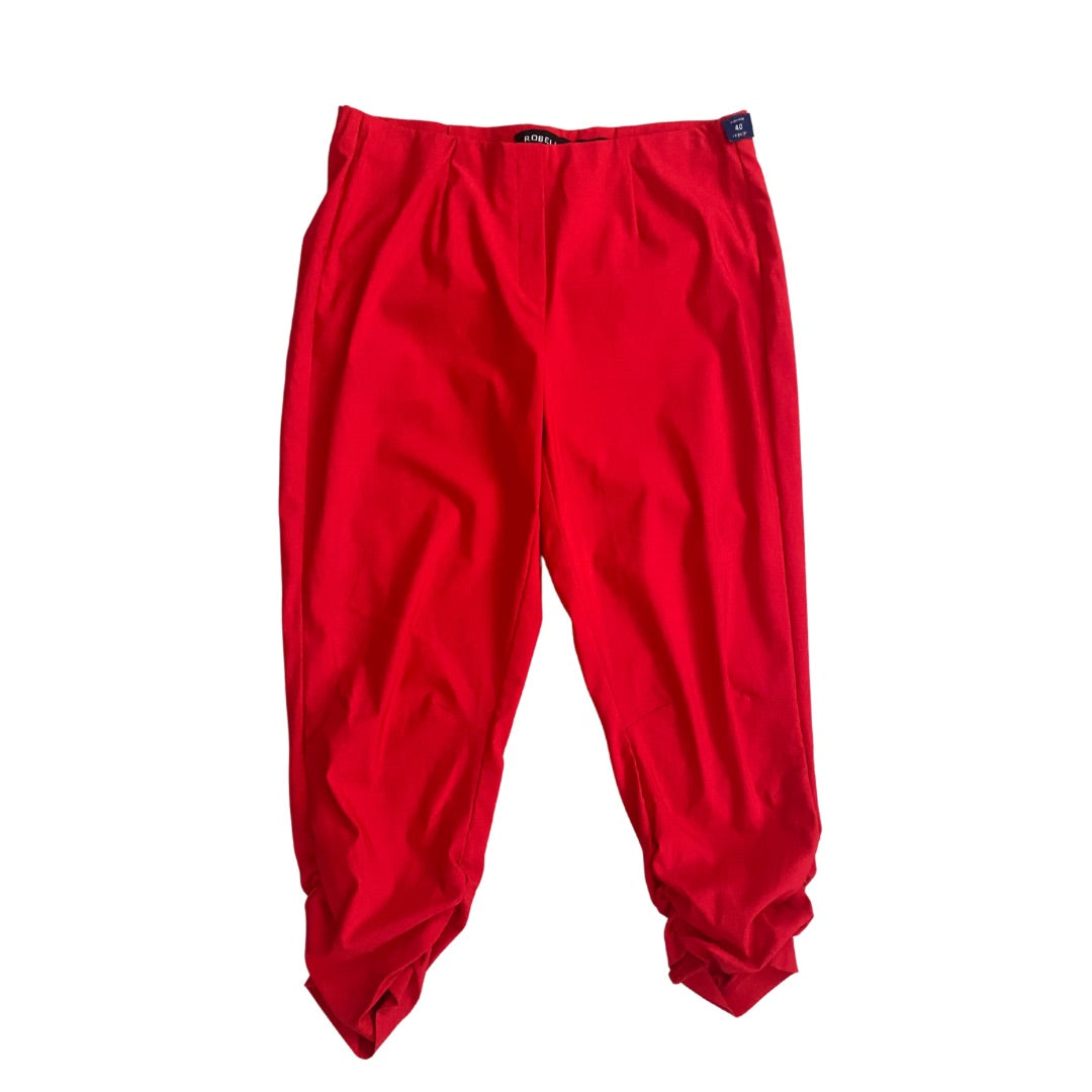Red capri pants with ruched detail at the ankles, elasticated waist, and brand tag visible.