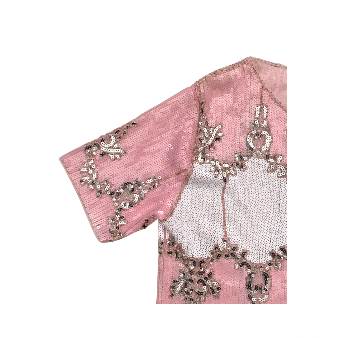Pink top fabric with intricate silver embroidery on a white background
