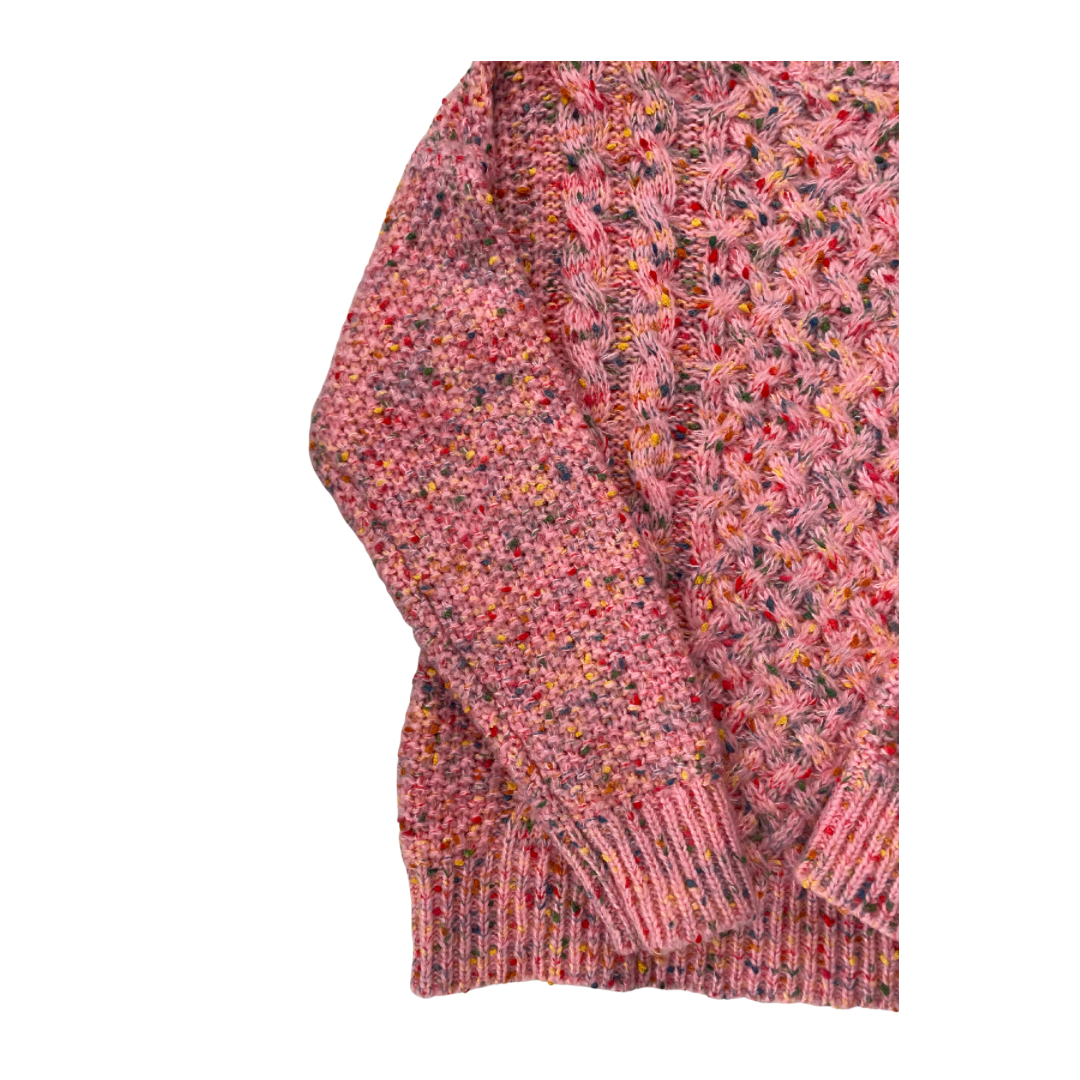 Close-up of a pink knitted sweater with a pattern on a white background