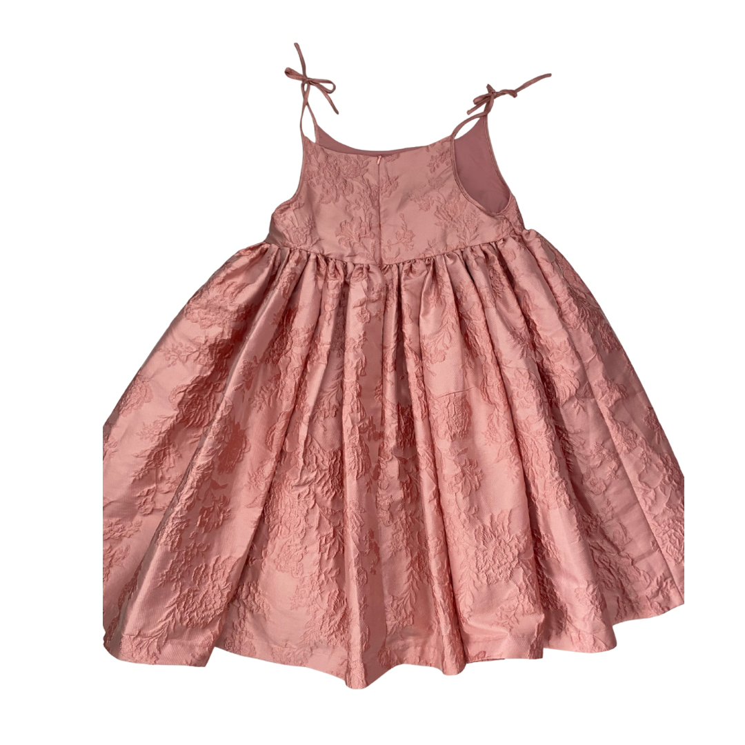 Pink dress with lace details on a white background