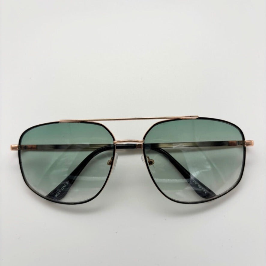 Aviator sunglasses with gold frame and green lenses on a white background