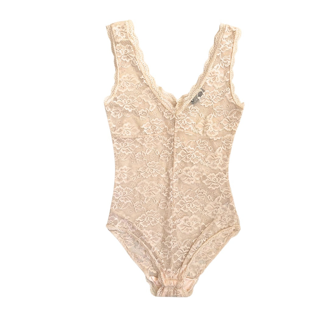 A beige floral lace pattern bodysuit with sleeveless design, double V-neck, and scalloped trim detail.