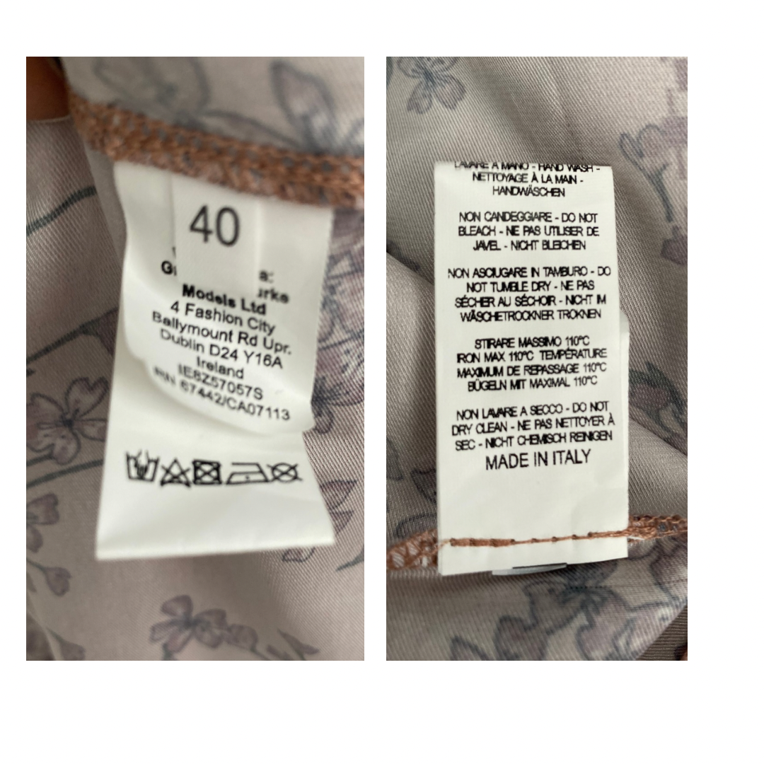 Two clothing labels with text and symbols on a fabric background