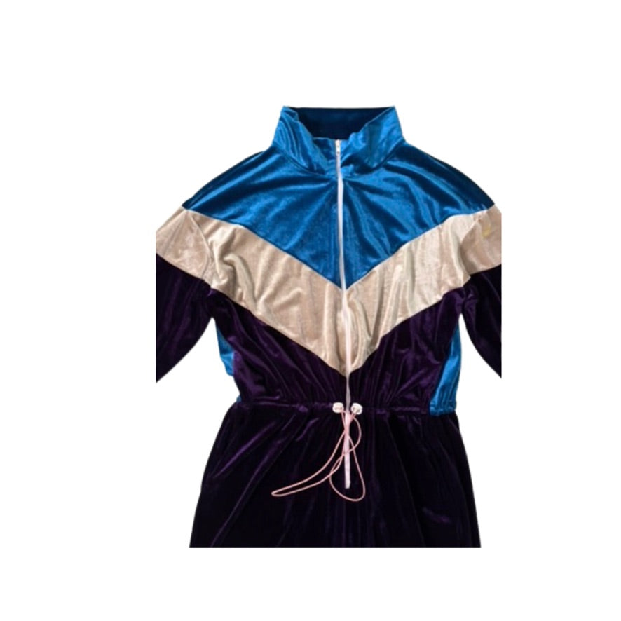 Color-blocked jumpsuit with blue, beige, and black sections on a white background