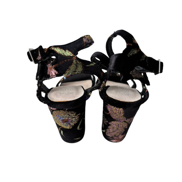 Pair of black and gold embroidered cymbal sandals on a white background