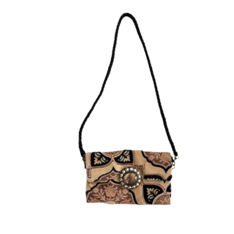 Crossbody bag with decorative pattern and central embellishment on a white background