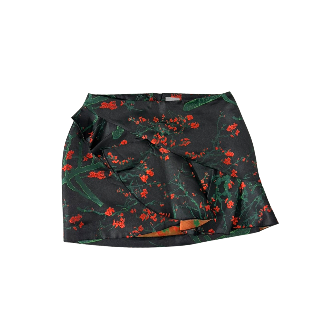 Black skirt with red and green floral pattern on a white background