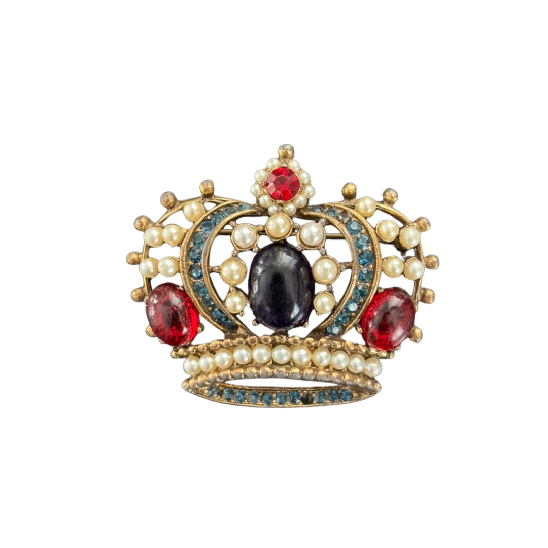 Decorative brooch with pearls, red and blue gemstones on a white background