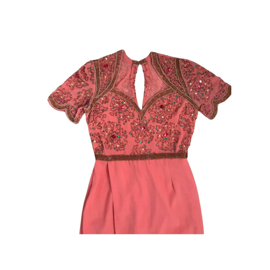 Coral dress with intricate beadwork on a white background