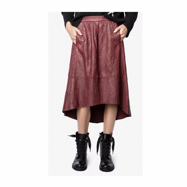 Person wearing a burgundy leather skirt and black boots on a white background