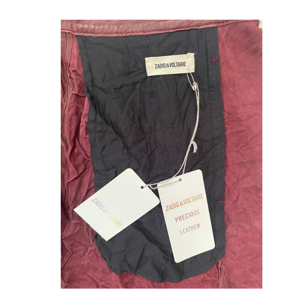 Black garment with Zadig & Voltaire tags on a burgungy fabric background
