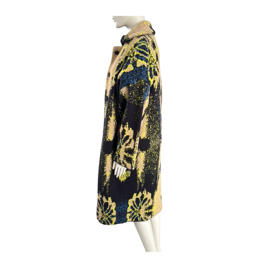 Mannequin wearing a patterned coat with yellow and blue design on a white background