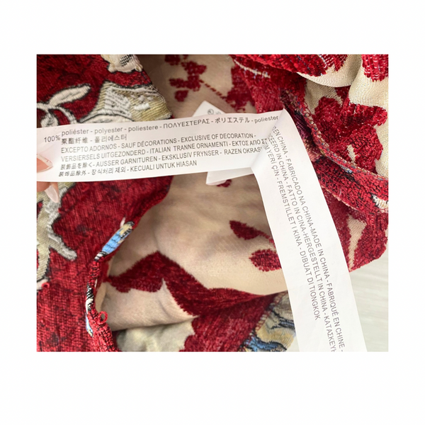 Close-up of a fabric with a floral pattern and a label on a white background