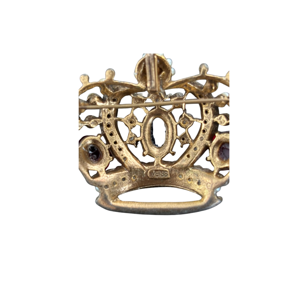 Gold crown-shaped jewelry piece with gemstones on a white background