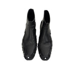 Pair of black leather boots with unique design on a white background