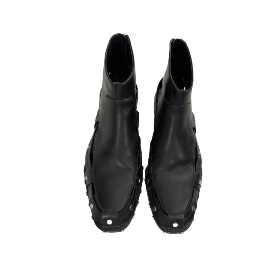 Pair of black leather boots with unique design on a white background
